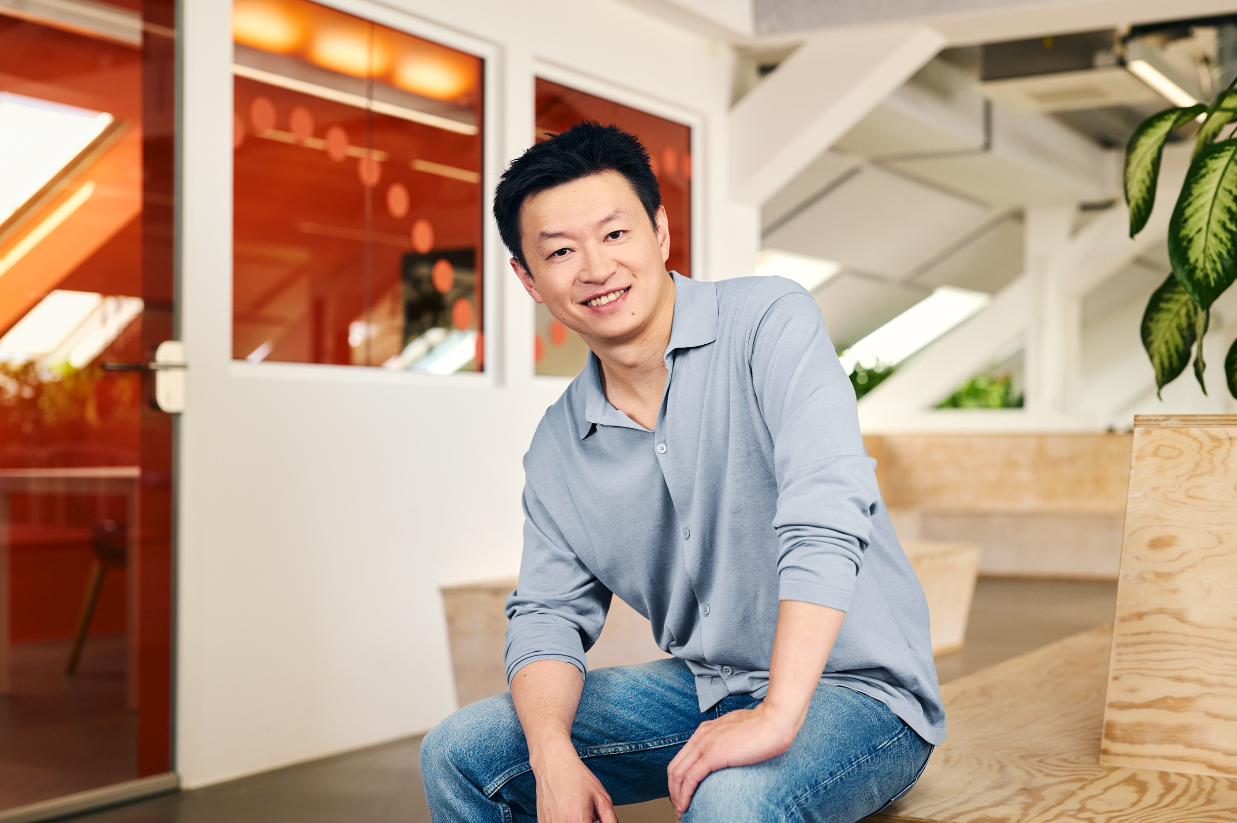 Tao Tao, GetYourGuide co-founder and chief operating officer, seated on stairs in a company press portrait